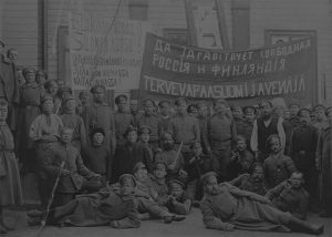 Venäläisiä sotilaita ja suomalaisia mahdollisesti Kajaanissa vuonna 1917. Vallankumouksen jälkeisissä tunnelmissa vapauden ajatus korostui lipuissa ja banderolleissa. Kuva: Työväen Arkisto. 